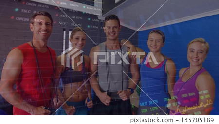 Standing five fitness members holding jump ropes in fitness studio, with financial chart overlay 135705189