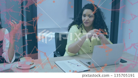 Woman in blouse speaking in boardroom with laptop, clipboard, pen, coffee cup under network overlay Woman in blouse speaking in boardroom with laptop, clipboard, pen, coffee cup under network overlay 135705191