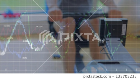 Rowing man in workout gear pulling rower handle toward chest at gym, with digital financial charts Rowing man in workout gear pulling rower handle toward chest at gym, with digital financial charts 135705235