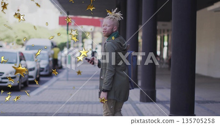 Standing light-skinned man glancing over shoulder on city sidewalk, with phone, gold star graphics 135705258