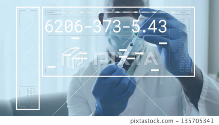 Clinician in lab coat drawing clear liquid from vial into syringe at desk, with data overlay 135705341