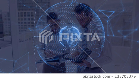 Analyzing holographic globe network in modern office, colleagues standing with tablet notebook pen Analyzing holographic globe network in modern office, colleagues standing with tablet notebook pen 135705379