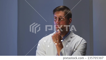 Gazing mid adult scientist wearing white lab coat in studio, with floating digital interface icons 135705387