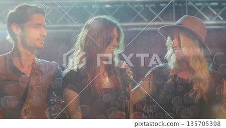 Jamming band playing under metal truss, with electric guitar, microphone, necklace and lighting rig Jamming band playing under metal truss, with electric guitar, microphone, necklace and lighting rig 135705398