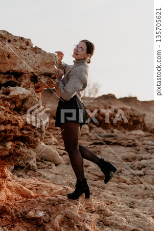 Woman Rock Climbing Outdoors: Sunset photoshoot showcasing adventurous spirit. Woman Rock Climbing Outdoors: Sunset photoshoot showcasing adventurous spirit. 135705621