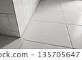 Pristine Bathroom Tiles. A close-up, eye-level shot focusing on the pristine, empty corner of a modern bathroom. Gleaming white tiles 135705647