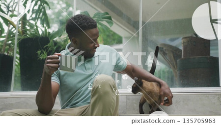 Sitting man holding mug, stroking cat by glass wall floating financial overlay, copy space Sitting man holding mug, stroking cat by glass wall floating financial overlay, copy space 135705963