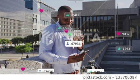 Checking social media alerts, man wearing shirt holding phone, coffee cup on terrace with bicycle 135706087