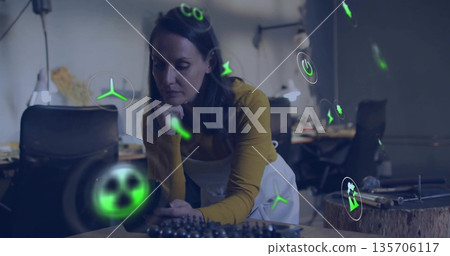Leaning female technician inspecting bearings on workbench in workshop, with green energy icons Leaning female technician inspecting bearings on workbench in workshop, with green energy icons 135706117