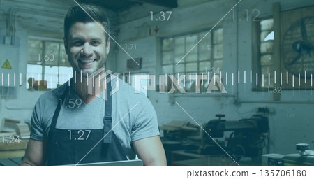Woodworker wearing apron holding laptop showing digital overlays near table saw in carpentry shop Woodworker wearing apron holding laptop showing digital overlays near table saw in carpentry shop 135706180
