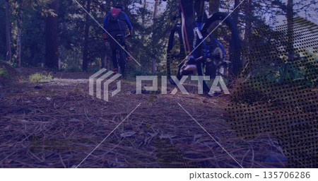 Two riders wearing hooded jacket and leggings cycling along pine forest trail, with bikes, backpack 135706286
