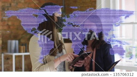 Analyzing world map overlay on tablet by two colleagues in blazers wearing face masks in office Analyzing world map overlay on tablet by two colleagues in blazers wearing face masks in office 135706312