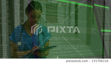 Writing Indian nurse on clipboard with pen in clinic with stethoscope, code overlay, copy space Writing Indian nurse on clipboard with pen in clinic with stethoscope, code overlay, copy space 135706316