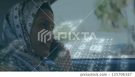 Calling on smartphone while woman in hijab and buckling seat belt, projecting binary overlay in car Calling on smartphone while woman in hijab and buckling seat belt, projecting binary overlay in car 135706387