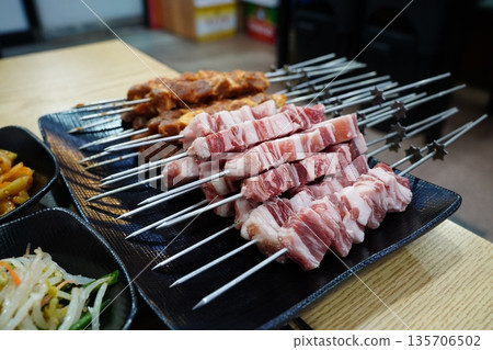 Raw and Marinated Lamb Skewers Prepared on a Black Plate Raw and Marinated Lamb Skewers Prepared on a Black Plate 135706502
