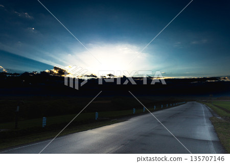 The setting sun and a straight road seen from the top of a hill in Biei, Hokkaido 135707146