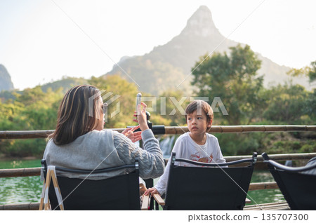 Mother And Child Sharing A Moment By The Picturesque Mountain View Mother And Child Sharing A Moment By The Picturesque Mountain View 135707300