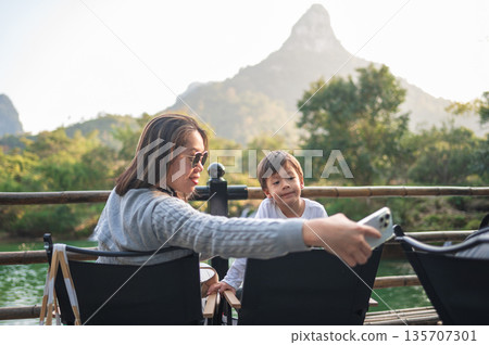 Snapping A Memory: Mother And Child Taking Selfie By The River Snapping A Memory: Mother And Child Taking Selfie By The River 135707301