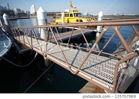 A walkway leading to the floating pier at Yokohama Port and a yellow ship 135707869