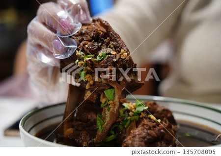 Traditional Thai Spicy Pork Ribs Soup (Tom Saap) with Fresh Chili and Green Onion Topping Traditional Thai Spicy Pork Ribs Soup (Tom Saap) with Fresh Chili and Green Onion Topping 135708005