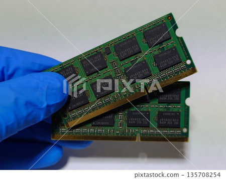 Holding two pieces of laptop (PC) main memory (RAM) in hand 135708254