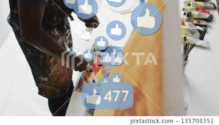 Mixing painter blending colors on palette in studio, thumbs-up icons, copy space 135708351