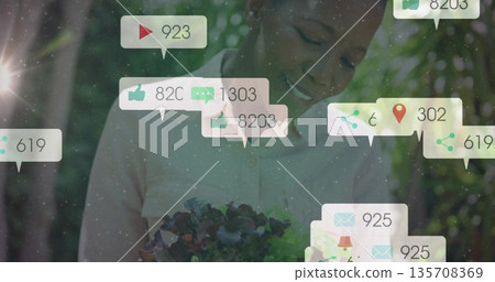 Displaying woman wearing shirt and holding succulent planter in garden, with social media icons 135708369