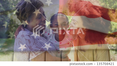 Embracing three-generation family smiling at each other in sunny park, with American flag overlay Embracing three-generation family smiling at each other in sunny park, with American flag overlay 135708421