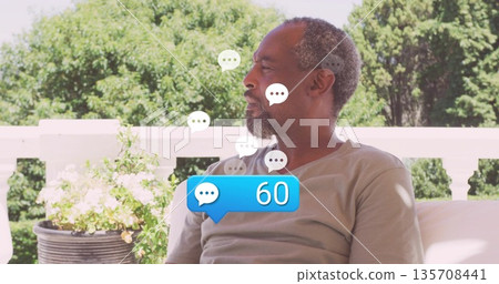Relaxing senior man wearing tee on porch sofa surrounded by floating 60 chat bubbles, copy space Relaxing senior man wearing tee on porch sofa surrounded by floating 60 chat bubbles, copy space 135708441