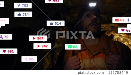 Exploring man wearing orange jacket navigating cave with helmet headlamp and notification icons Exploring man wearing orange jacket navigating cave with helmet headlamp and notification icons 135708449