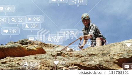 Scaling climber wearing helmet harness rope on sandstone face with floating icons, copy space Scaling climber wearing helmet harness rope on sandstone face with floating icons, copy space 135708501