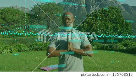 Standing African American man wearing sportswear praying on garden lawn, yoga mat data overlay Standing African American man wearing sportswear praying on garden lawn, yoga mat data overlay 135708513