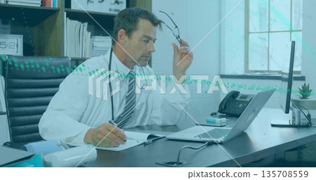 Removing eyeglasses male doctor wearing lab coat writing notes in medical office with stethoscope 135708559