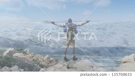 Spreading arms man in hiking gear on rocky coastal cliff, with large backpack and hiking boots Spreading arms man in hiking gear on rocky coastal cliff, with large backpack and hiking boots 135708633