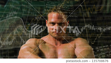 Showing shirtless athlete flexing muscles in studio, with stock market graphs and tickers Showing shirtless athlete flexing muscles in studio, with stock market graphs and tickers 135708676