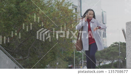 Descending businesswoman carrying brown bag, using smartphone, checking watch in plaza, copy space Descending businesswoman carrying brown bag, using smartphone, checking watch in plaza, copy space 135708677
