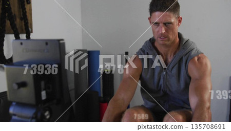 Pulling rowing handle, muscular man leaning in workout room with foam rollers, console, copy space Pulling rowing handle, muscular man leaning in workout room with foam rollers, console, copy space 135708691