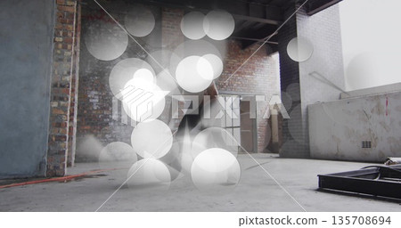Jumping male dancer wearing sleeveless top dark pants in warehouse loft with exposed brick red cord Jumping male dancer wearing sleeveless top dark pants in warehouse loft with exposed brick red cord 135708694