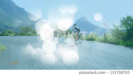 Pedaling cyclist riding asphalt mountain road with road bike, metal guardrail and cycling helmet Pedaling cyclist riding asphalt mountain road with road bike, metal guardrail and cycling helmet 135708705