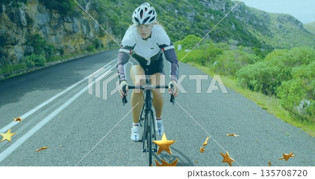 Riding woman wearing cycling jersey pedaling on winding mountain road, with helmet and bicycle Riding woman wearing cycling jersey pedaling on winding mountain road, with helmet and bicycle 135708720