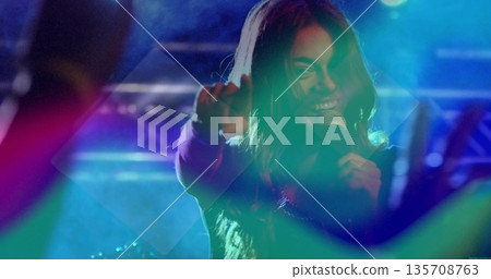 Female singer singing and pointing on center stage under vibrant lighting, with microphone and haze Female singer singing and pointing on center stage under vibrant lighting, with microphone and haze 135708763