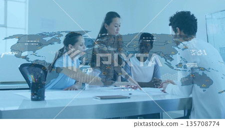 Businesswomen reviewing documents and pointing in boardroom, with tablet and world map overlay Businesswomen reviewing documents and pointing in boardroom, with tablet and world map overlay 135708774