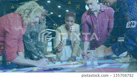 Collaborating coworkers writing on colored papers around table in office under network overlays Collaborating coworkers writing on colored papers around table in office under network overlays 135708782