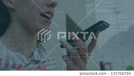 Speaking coder in striped sweatshirt holding phone at mouth in room, with code overlay, copy space 135708789