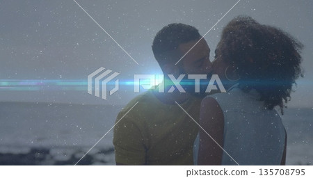 Sharing kiss, romantic couple embracing on rocky shoreline at dusk, with bright lens flare Sharing kiss, romantic couple embracing on rocky shoreline at dusk, with bright lens flare 135708795