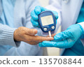 Asian doctor using digital glucose meter for check sample blood sugar level to treatment diabetes. 135708844