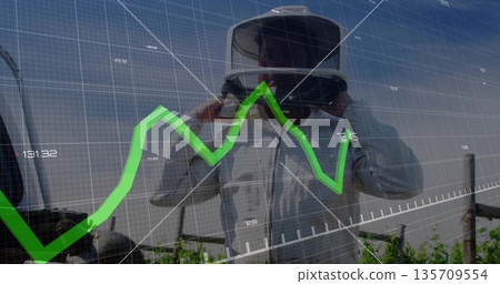 Adjusting VR headset, man in protective coat viewing green line chart overlay over vineyard rows Adjusting VR headset, man in protective coat viewing green line chart overlay over vineyard rows 135709554