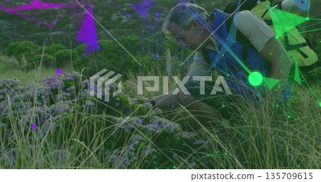 Inspecting purple flowers, hiker kneeling in meadow, with yellow backpack, data overlay, copy space Inspecting purple flowers, hiker kneeling in meadow, with yellow backpack, data overlay, copy space 135709615