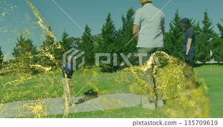 Swinging man hitting bunker shot with golf club on fairway, golfers watching under spark overlay Swinging man hitting bunker shot with golf club on fairway, golfers watching under spark overlay 135709619