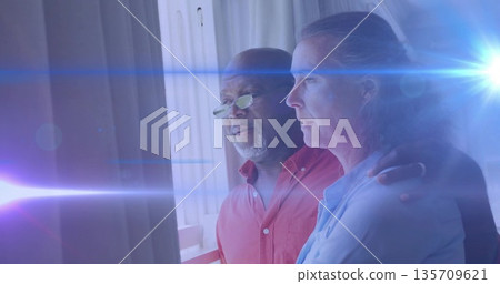 Black man and White woman standing by balcony railing at home, with tinted spectacles, lens flare 135709621